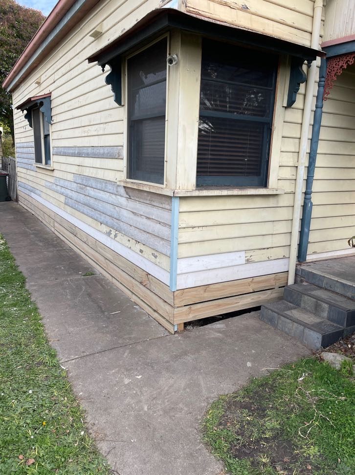 New timber weatherboards spliced into the bottom courses around a bay window