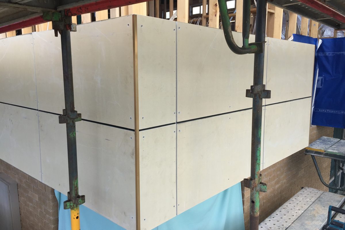 Fibre cement panels fixed over a brick lower storey from scaffold