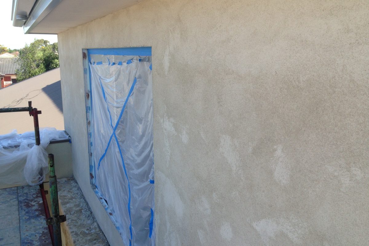Freshly rendered wall with the window masked off