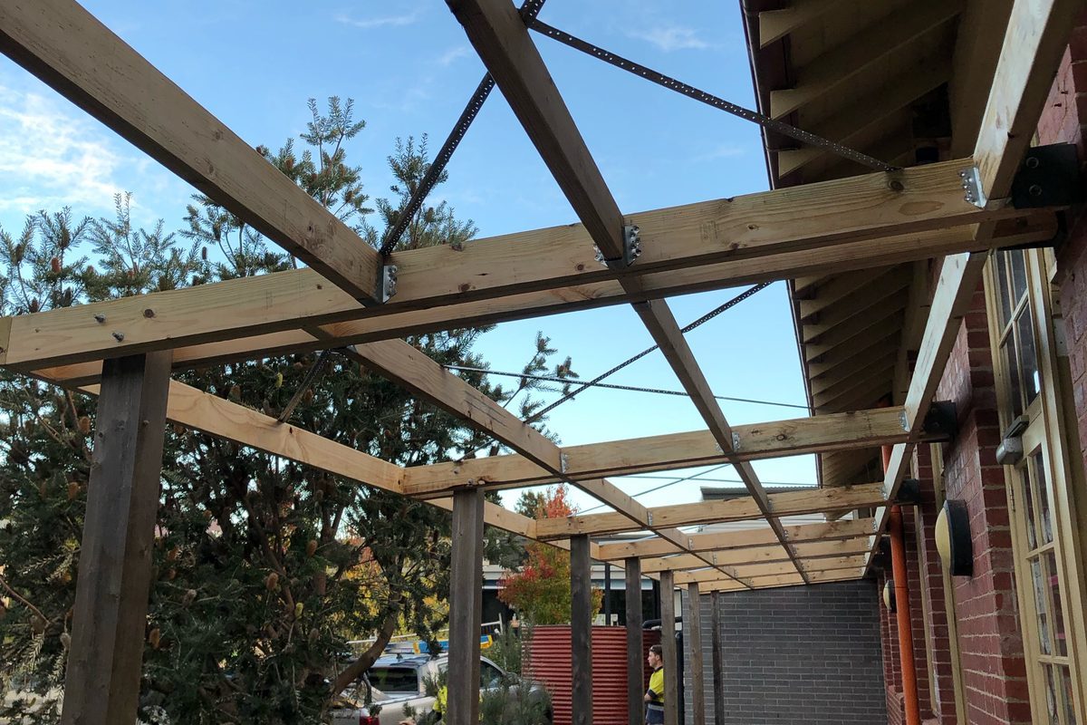 Timber pergola walkway framed along a school building