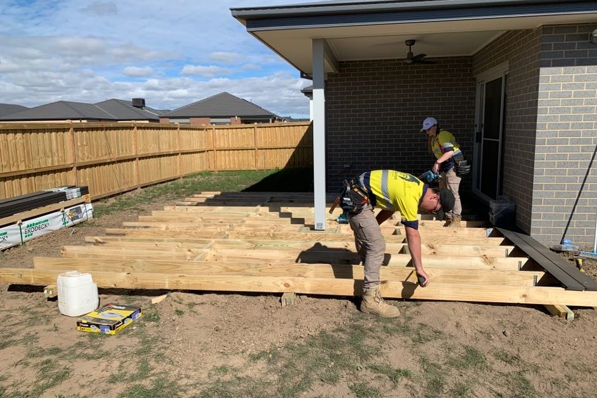 JFM carpenters framing a new deck on galvanised stirrups beside a new home