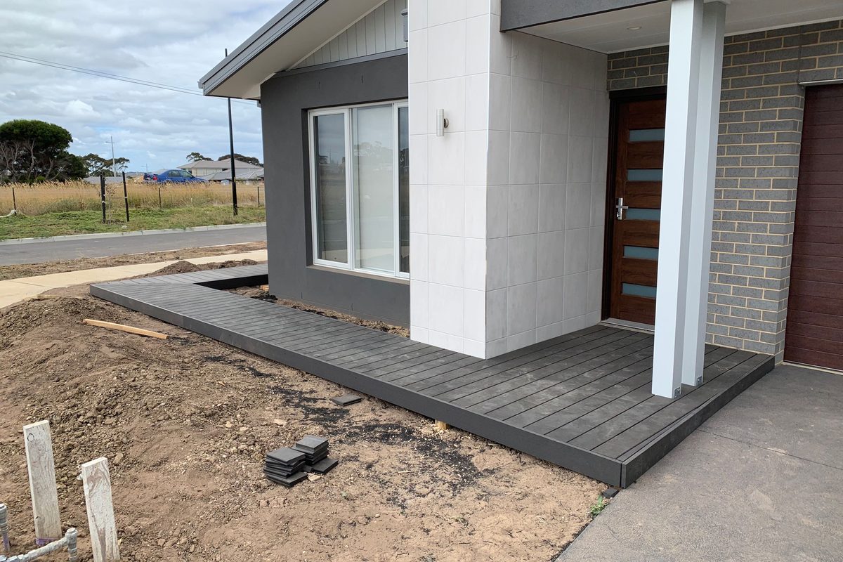 Grey composite deck wrapping the front of a new home in Charlemont, built by JFM