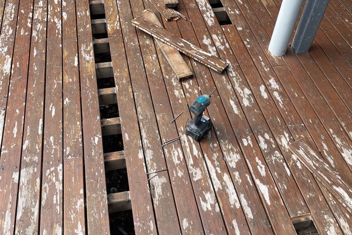 Broken boards cut out with the joists showing underneath, part-way through a JFM deck repair