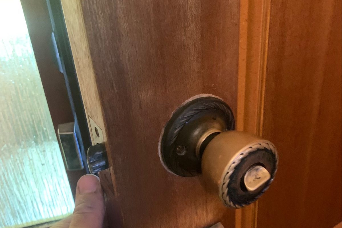 Worn knob set and lock on an old timber back door before it was replaced