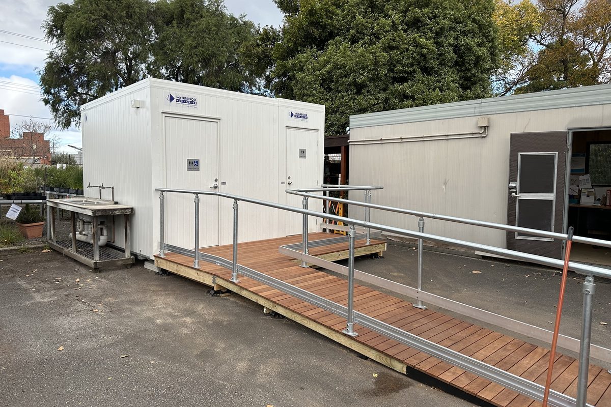 Accessible toilet building with a timber ramp and handrails installed for a site