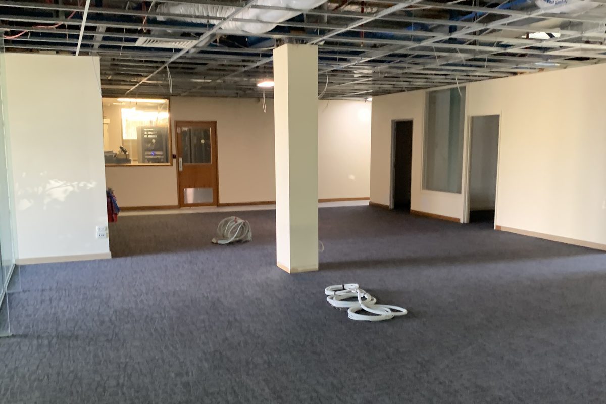 Office floor stripped to the ceiling grid at the start of a fit-out