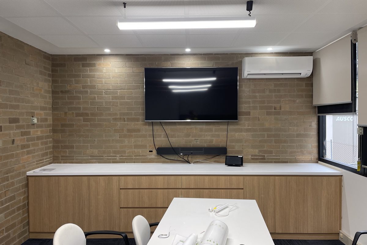 Meeting room fit-out with timber joinery under a wall-mounted screen