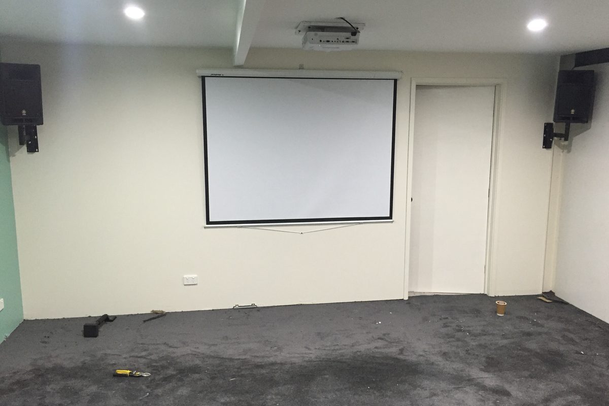 Finished training room with new walls, carpet and projector screen