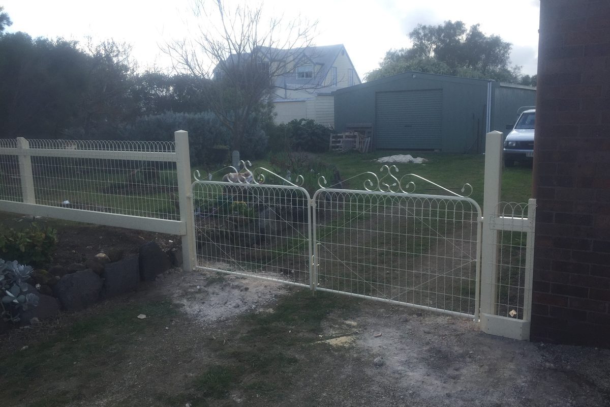 Painted double wire gates on a post-and-rail front fence