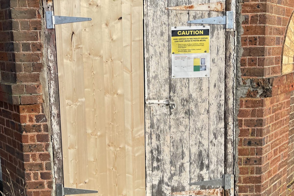 New timber door made to match, hung beside the original weathered door