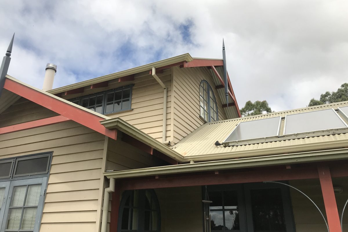 Period weatherboard home with restored gable trims and finials