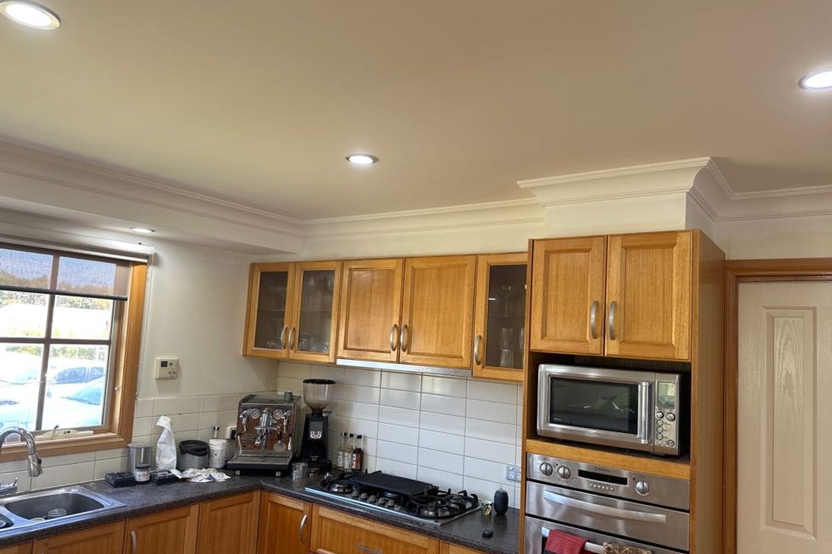 Kitchen ceiling and bulkheads replastered and painted by JFM after a leak from the bathroom upstairs
