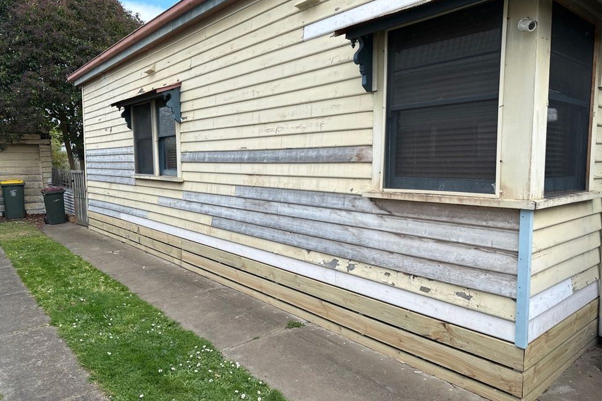 New weatherboards cut in along the bottom of an older home, before painting