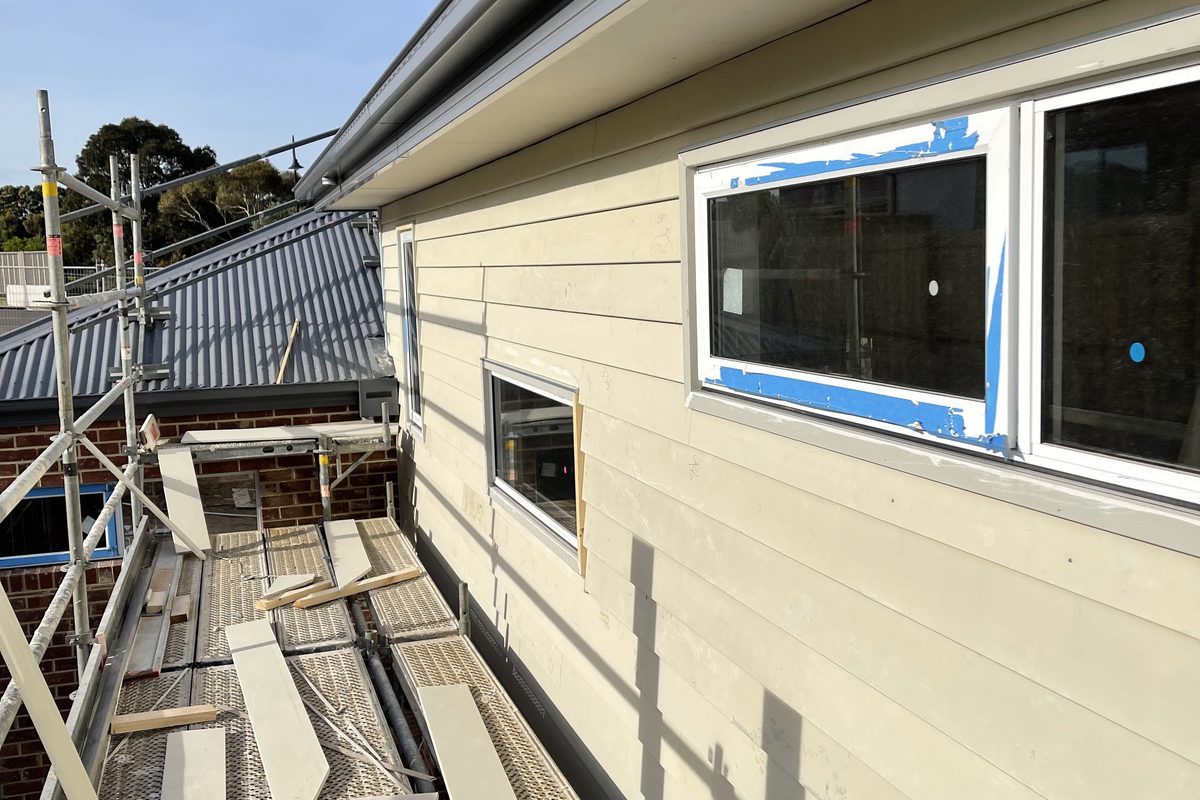 New fibre cement weatherboards going on a house from scaffold