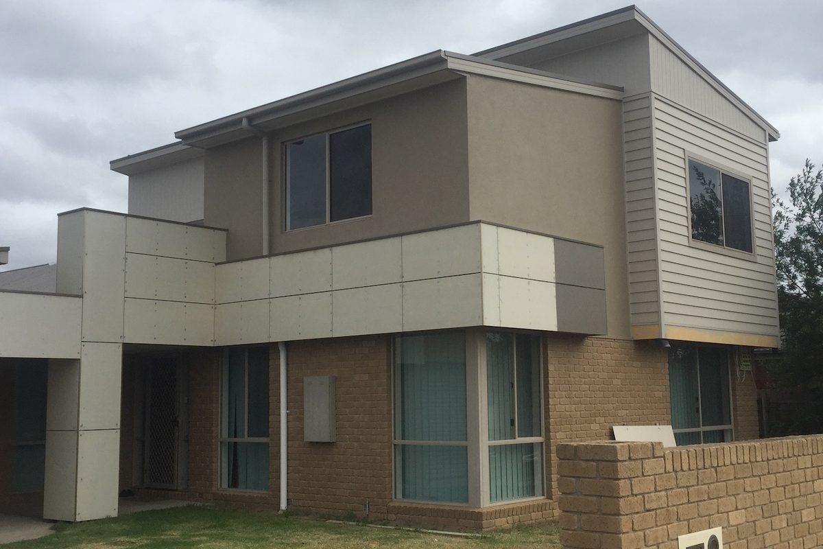 Two-storey home re-clad with new weatherboards and panels by JFM