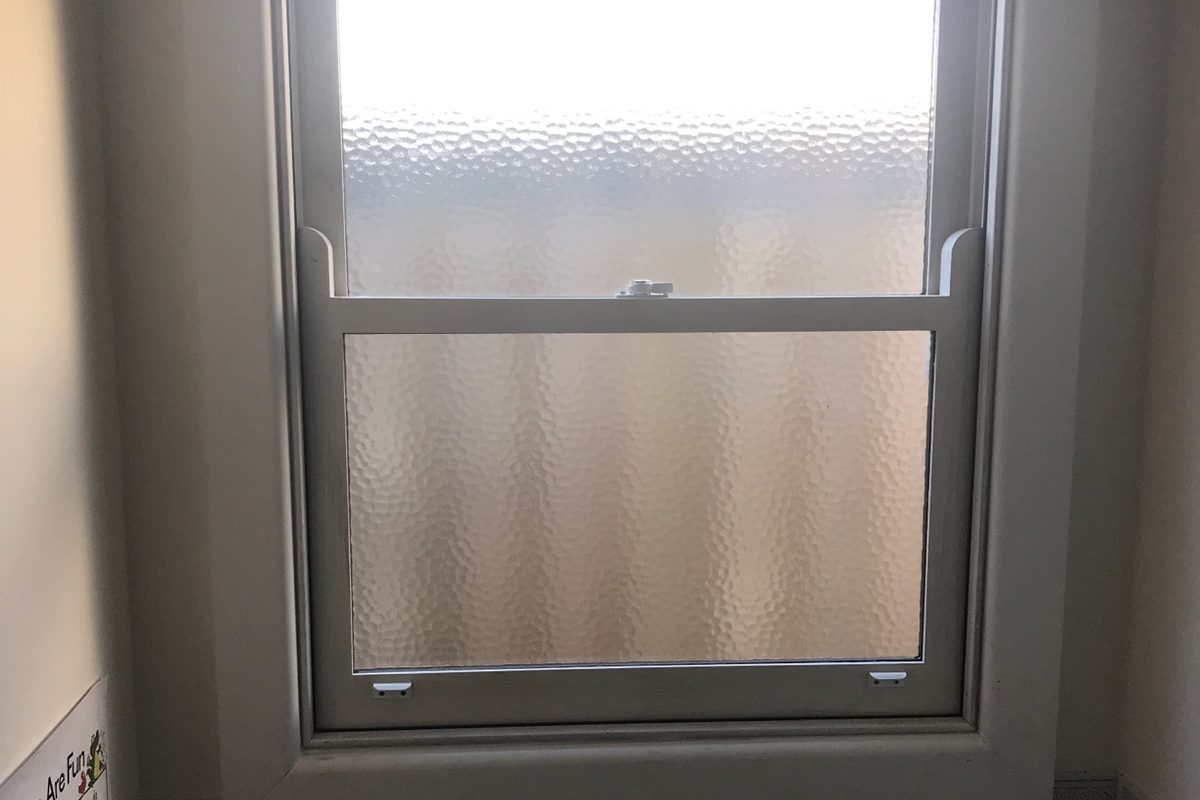 Double-hung sash window with obscure glass in a bathroom