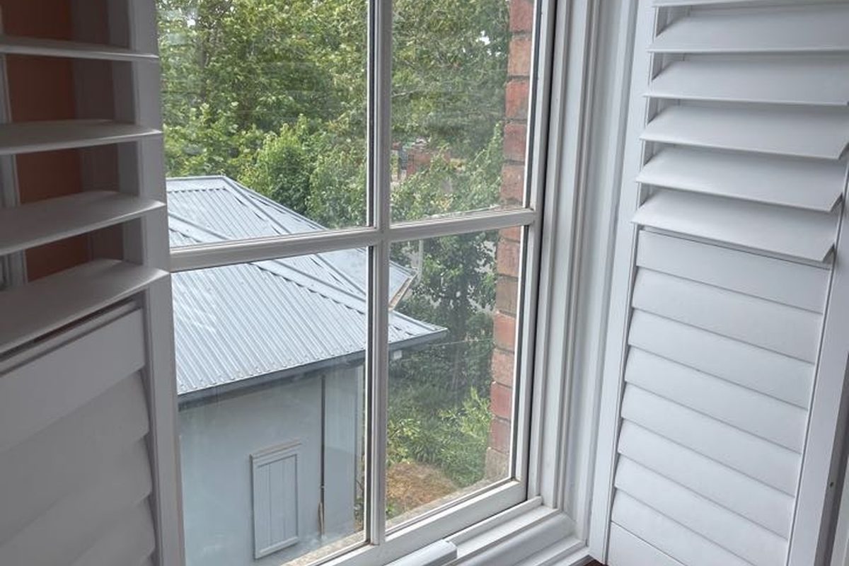 New white timber window with the original trims refitted, inside a Newtown home