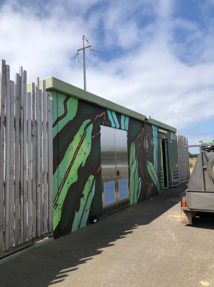 The finished stainless doors set into the muralled building wall